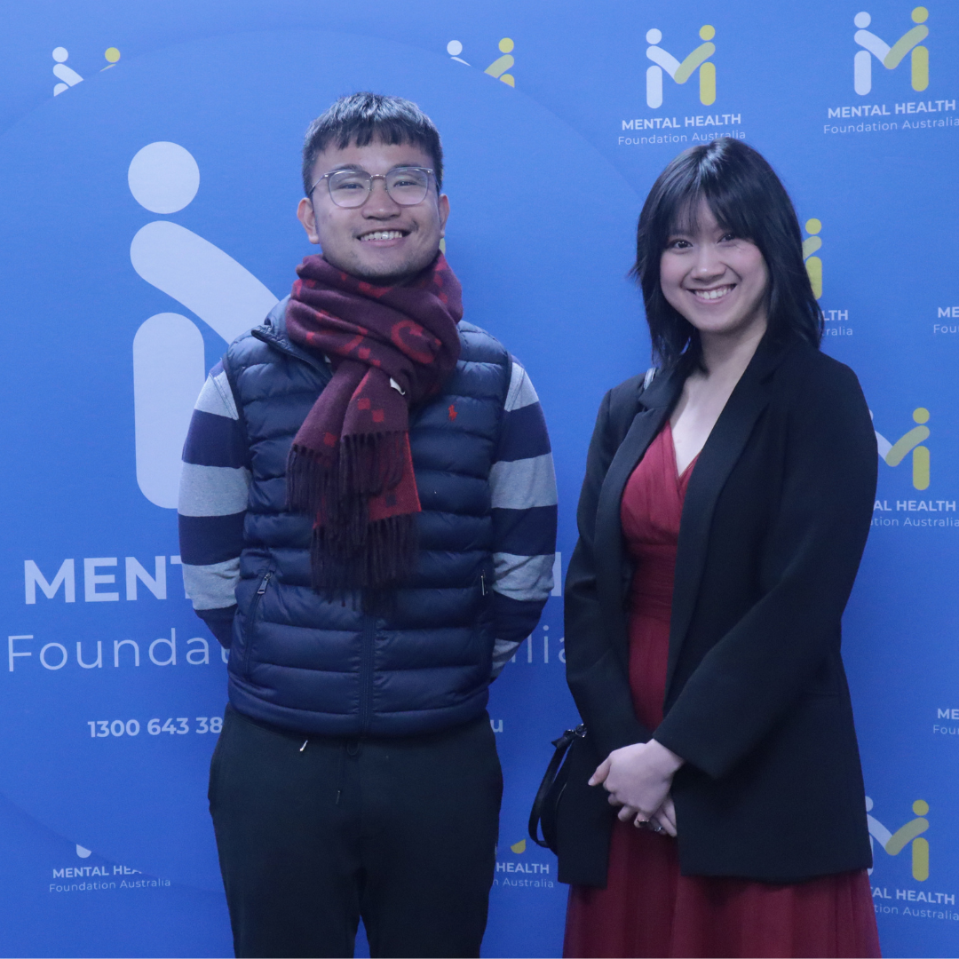 Two people posing in front of a blue Mental Health Foundation backdrop.