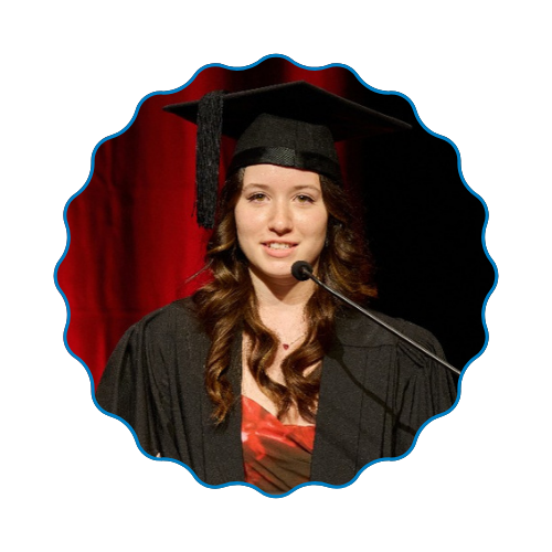 Graduate speaking at podium in cap and gown, framed by a red curtain backdrop.
