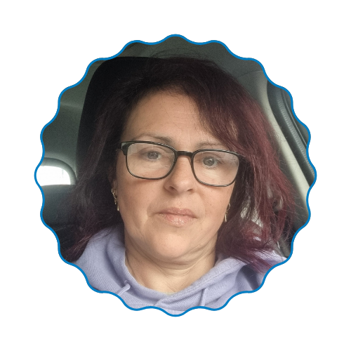 Portrait of a woman with glasses and dark hair, wearing a lavender hoodie in a car