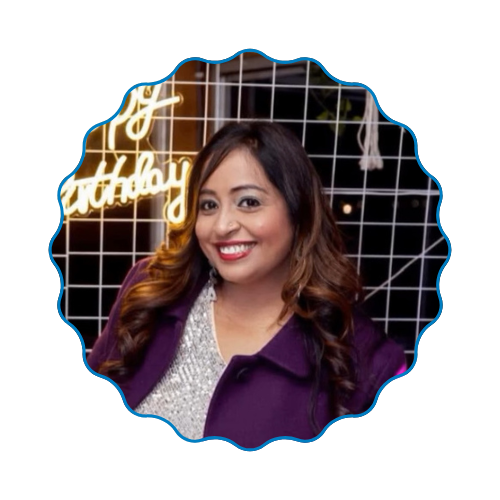 Smiling woman in a purple jacket posed in front of a decorative grid backdrop with glowing script lights