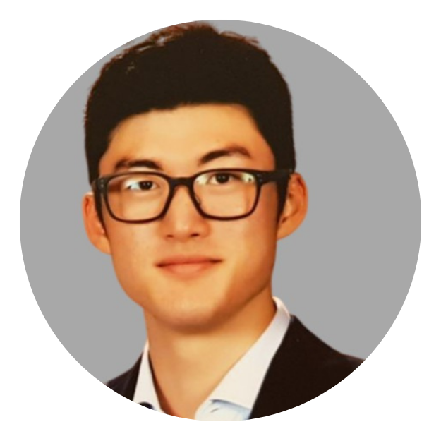 Portrait of a person wearing glasses and a dark blazer on a light gray background
