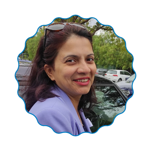Smiling woman in a lavender top beside a car in a parking lot with trees behind her