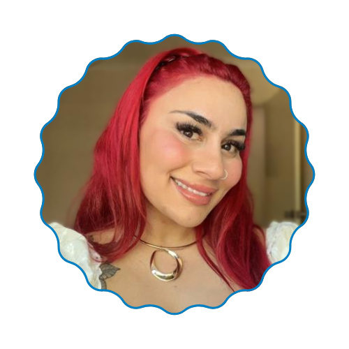 Smiling person with bright red hair in a scalloped blue-framed portrait