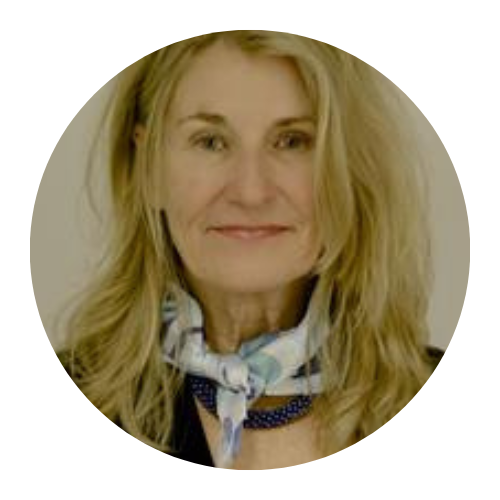 Portrait of a smiling woman with blonde hair wearing a patterned scarf.