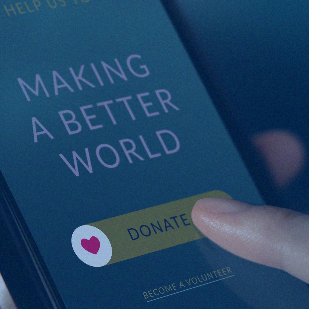 Hand pressing a yellow “Donate” button on a blue “Making a Better World” screen
