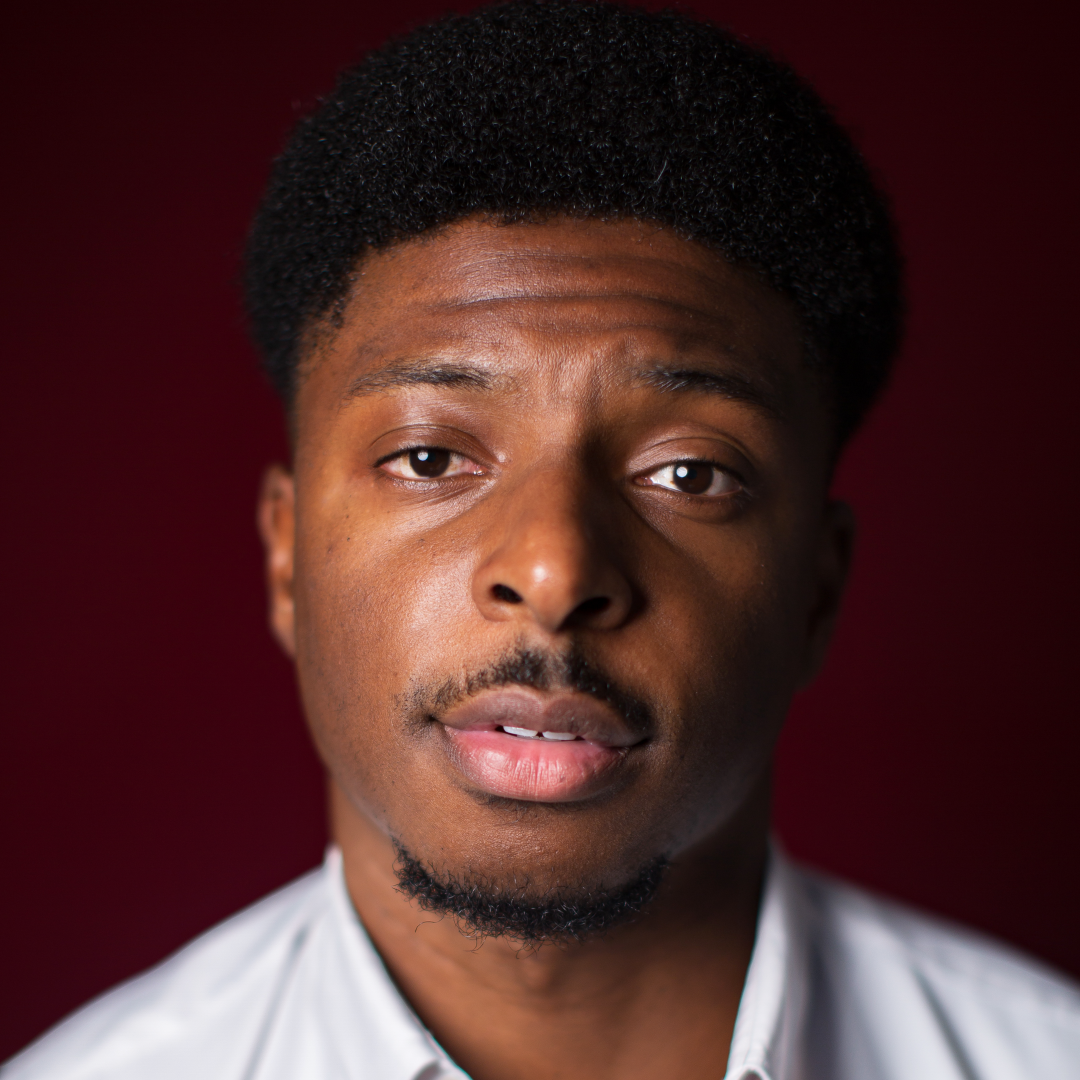 Studio portrait of a person with a neutral expression against a dark red background