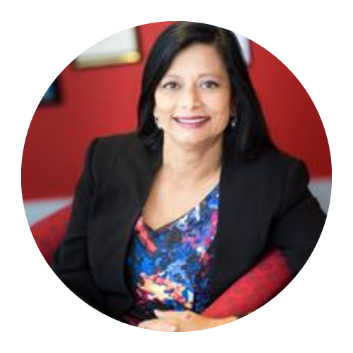 Portrait of a smiling woman in a black blazer and colorful top against a red background