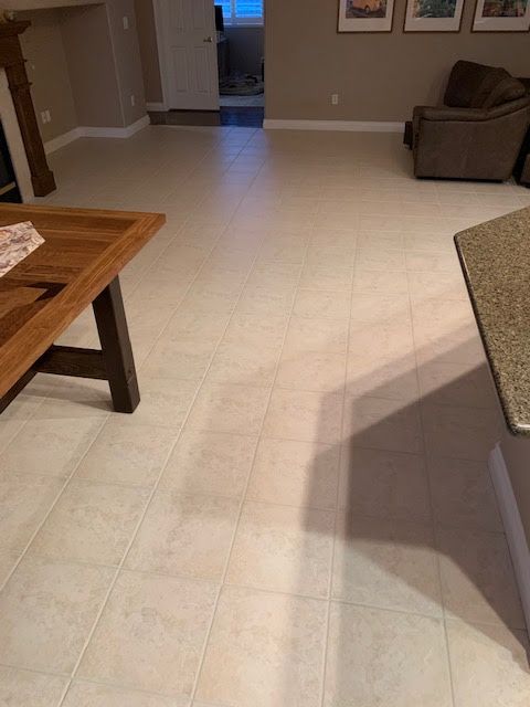 A living room with white tile floors and a wooden table.