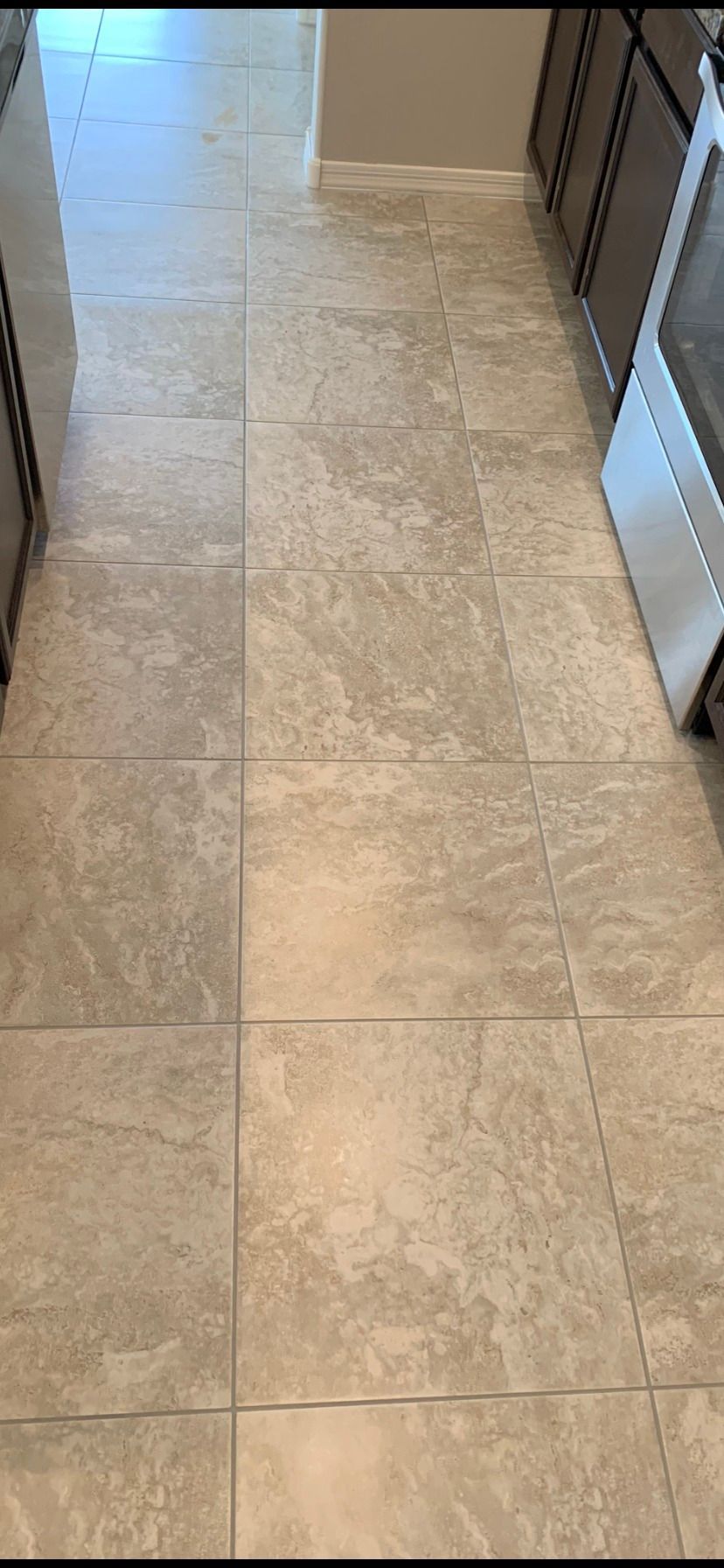 A kitchen with a tile floor and stainless steel appliances.