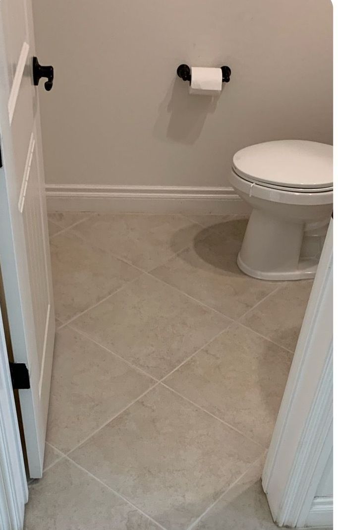 A toilet is sitting in a bathroom next to a door.