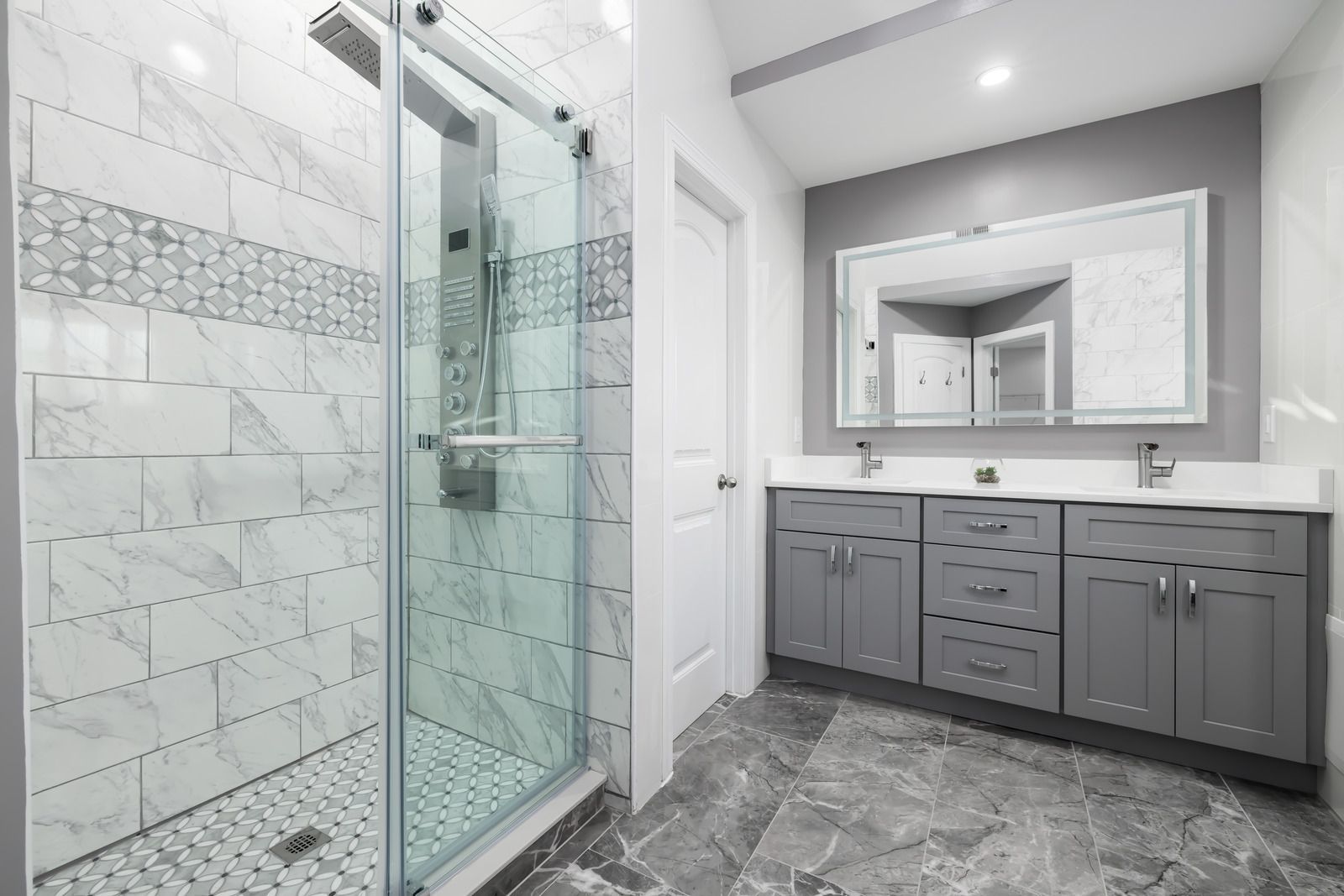 Modern bathroom with marble walls, skylight, and white fixtures.