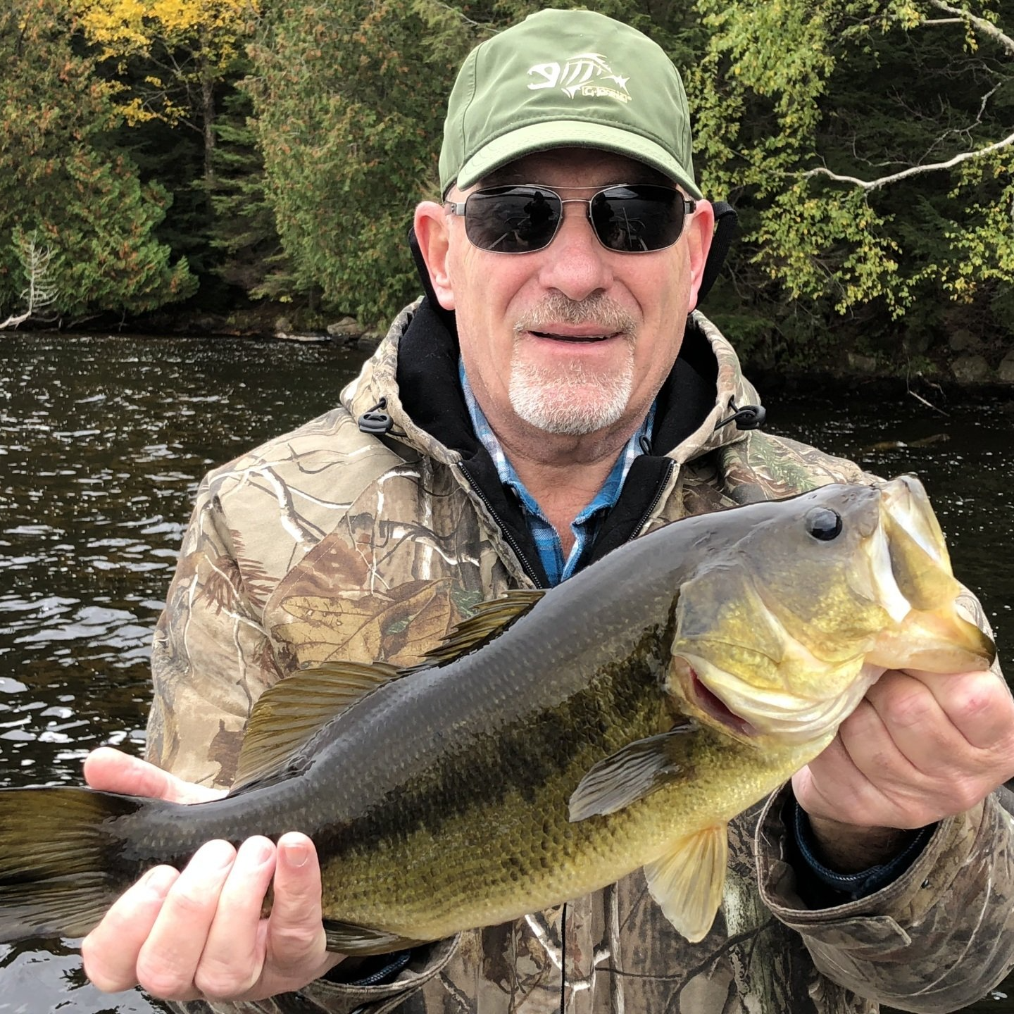 A man is holding a large fish in his hands.