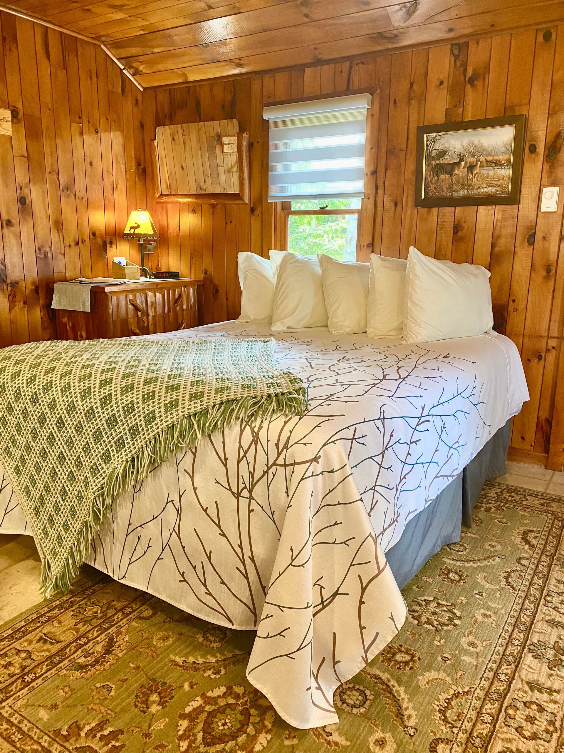 Evergreen cottage bedroom with wooden walls.