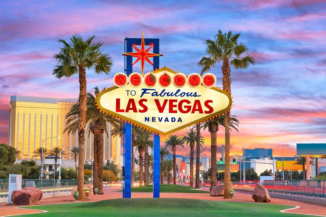 A las vegas sign with palm trees in the background.