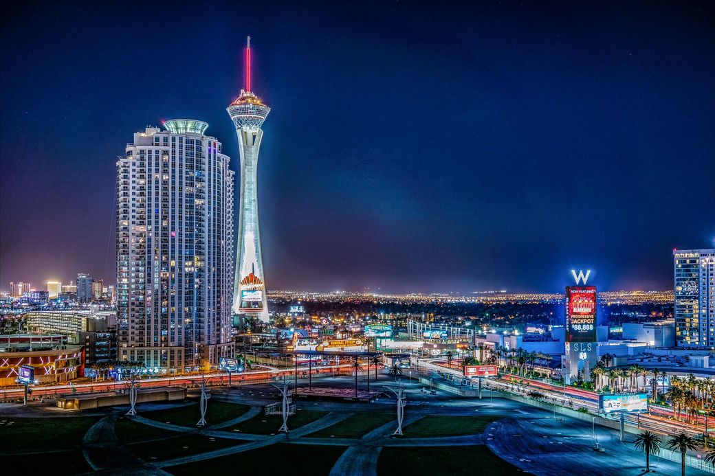 An aerial view of a city at night with a tower in the foreground.
