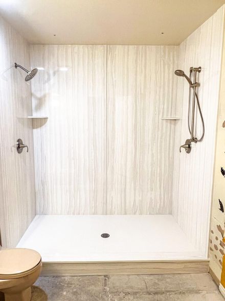Empty white walk-in shower with two showerheads