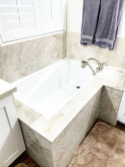 Corner bathtub with chrome faucet in a bright bathroom