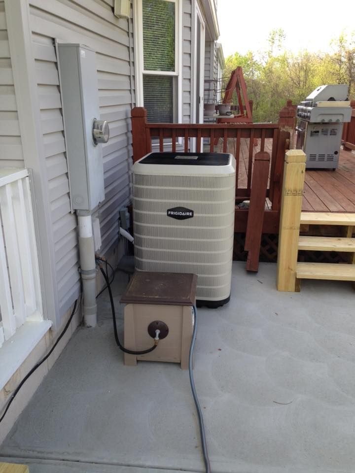 Frigidaire HVAC outdoor unit installation for residential cooling system on concrete patio
