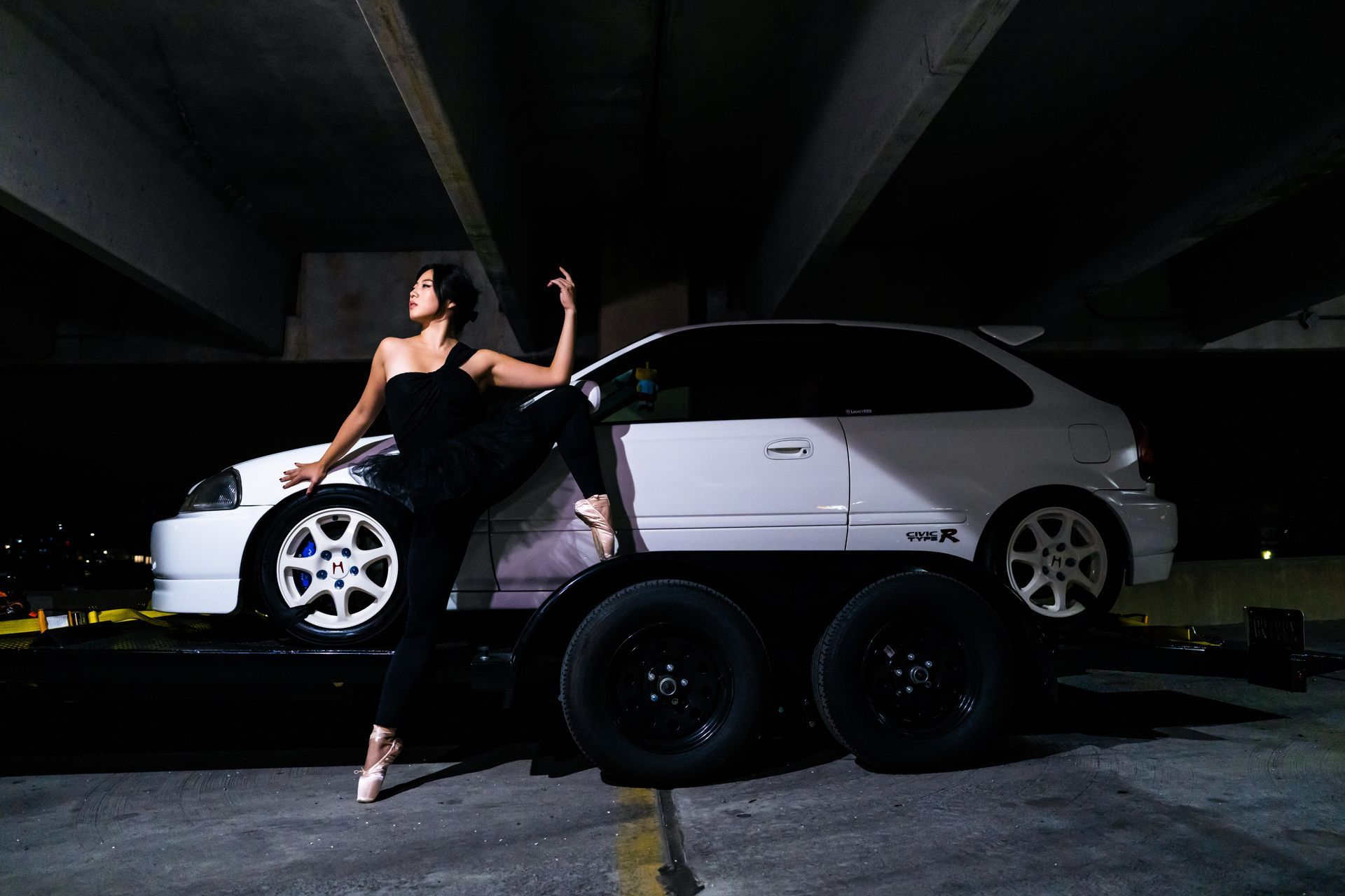 Conceptual portrait combining ballet technique with industrial automotive forms