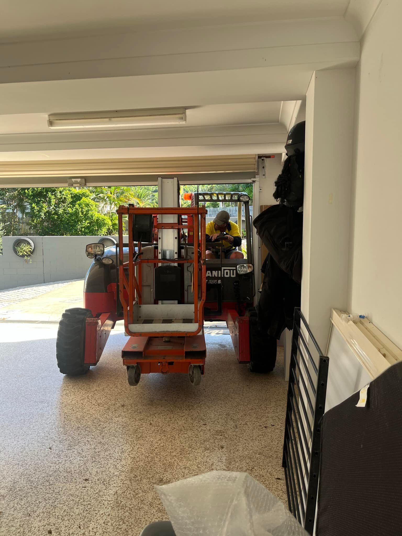 Red Lift Vehicle Inside a Building, Possibly a Garage — J & M Transport Plus in Barmaryee, QLD