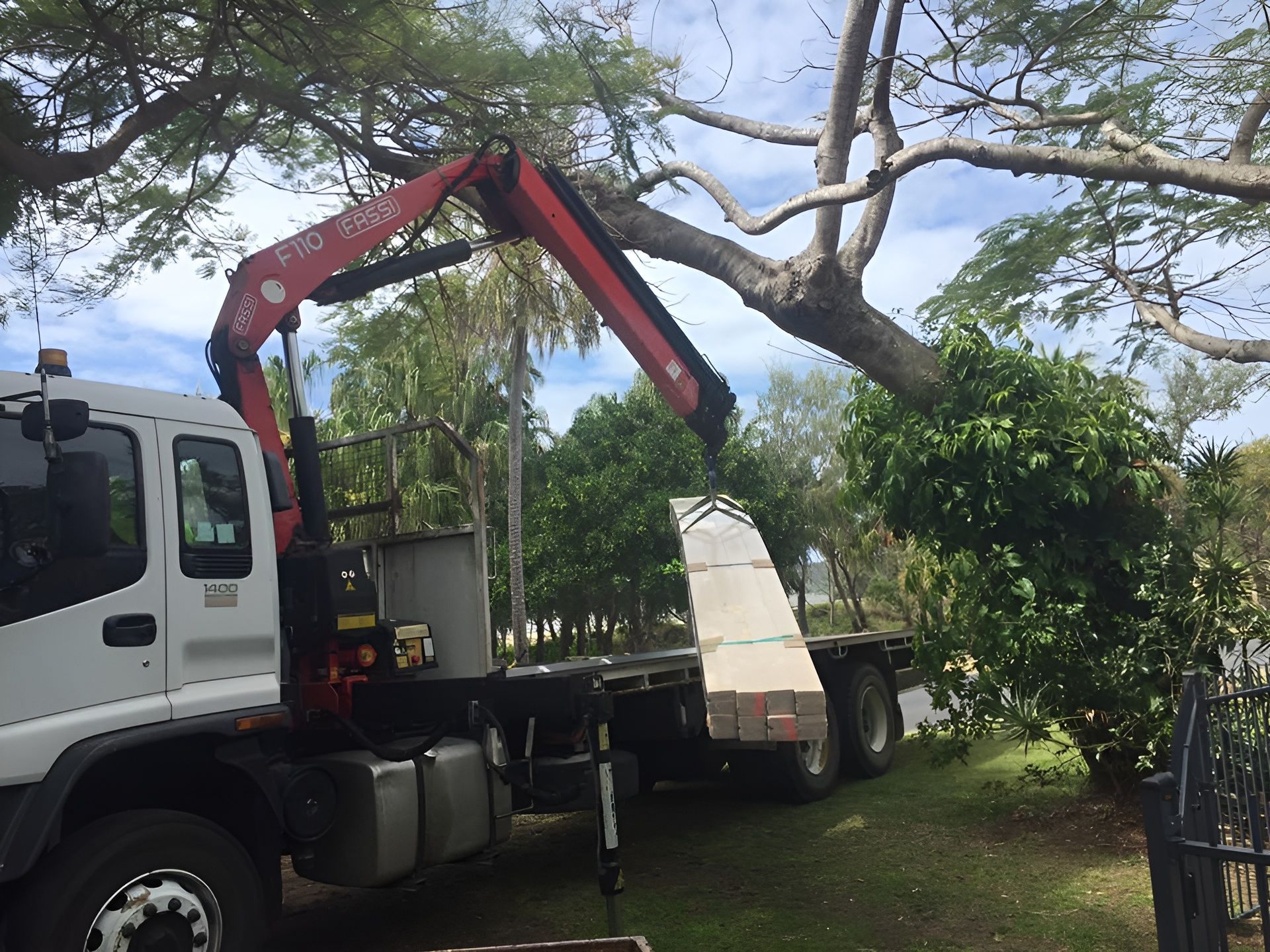 Truck with A Crane Lifting Lumber Near a Tree, Outdoors — J & M Transport Plus in Barmaryee, QLD