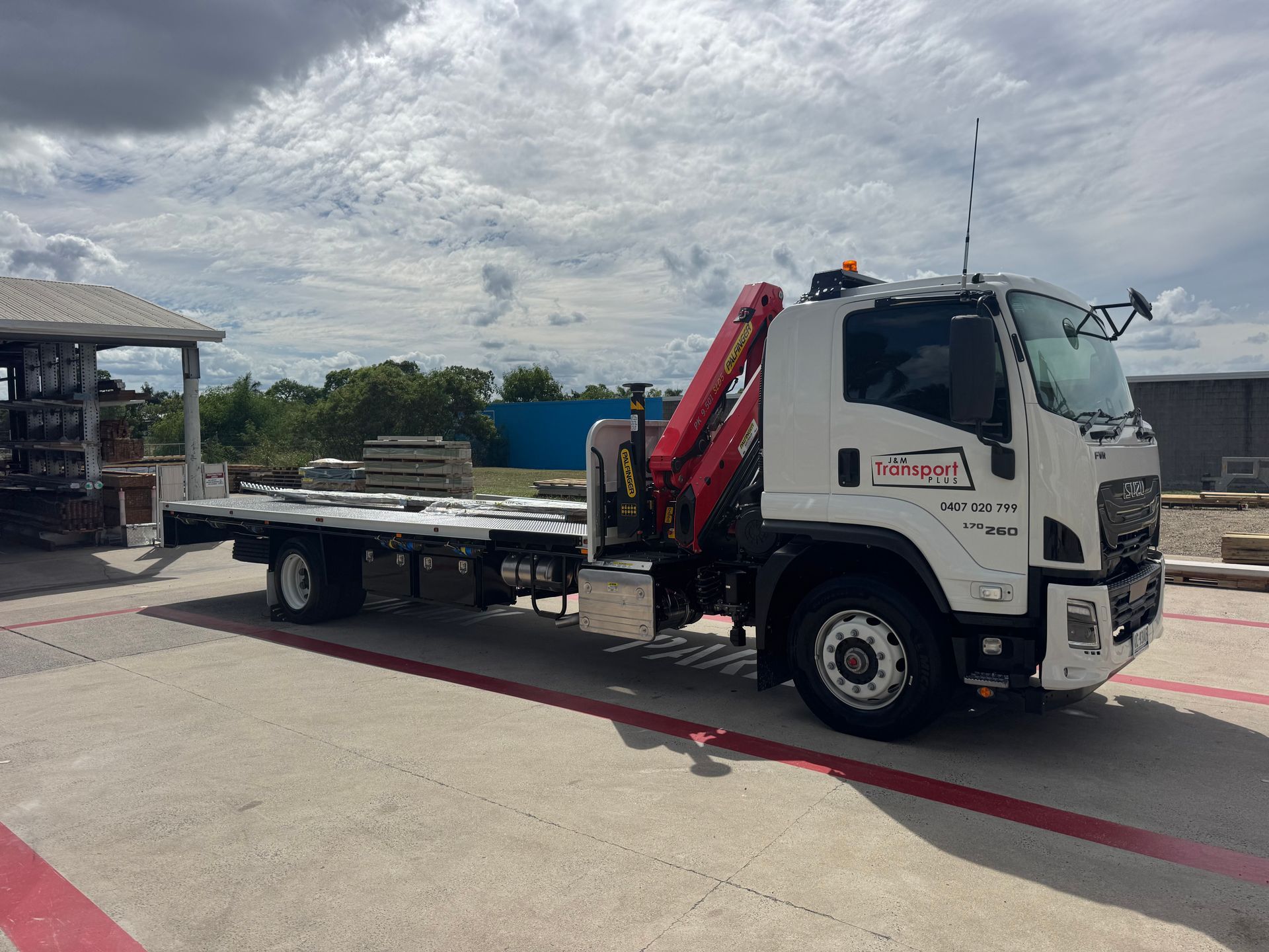 Two Tow Trucks Parked on A Sunny Day Near Trees — J & M Transport Plus in Rockhampton, QLD