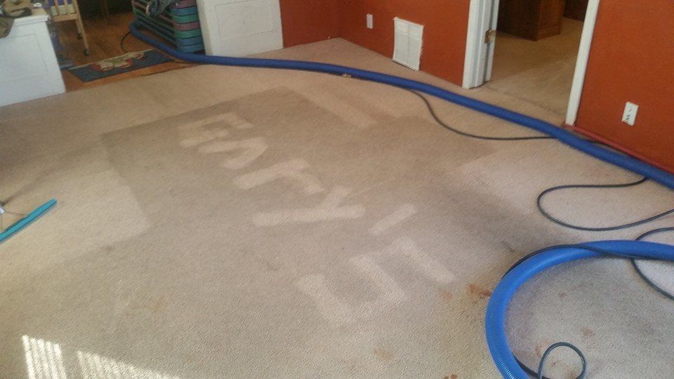 A vacuum cleaner is sitting on a dirty carpet in a room.