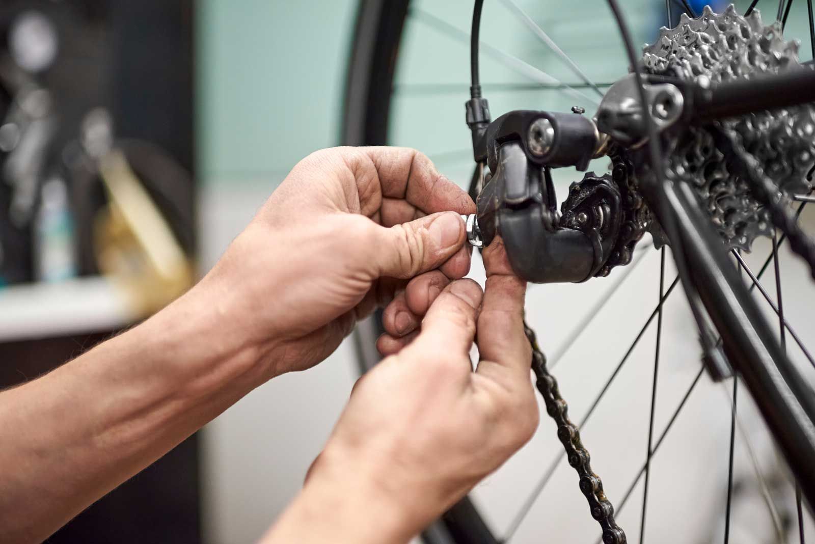 Cykelmekaniker justerer bagskifter på cykel hos Værløse Cykler