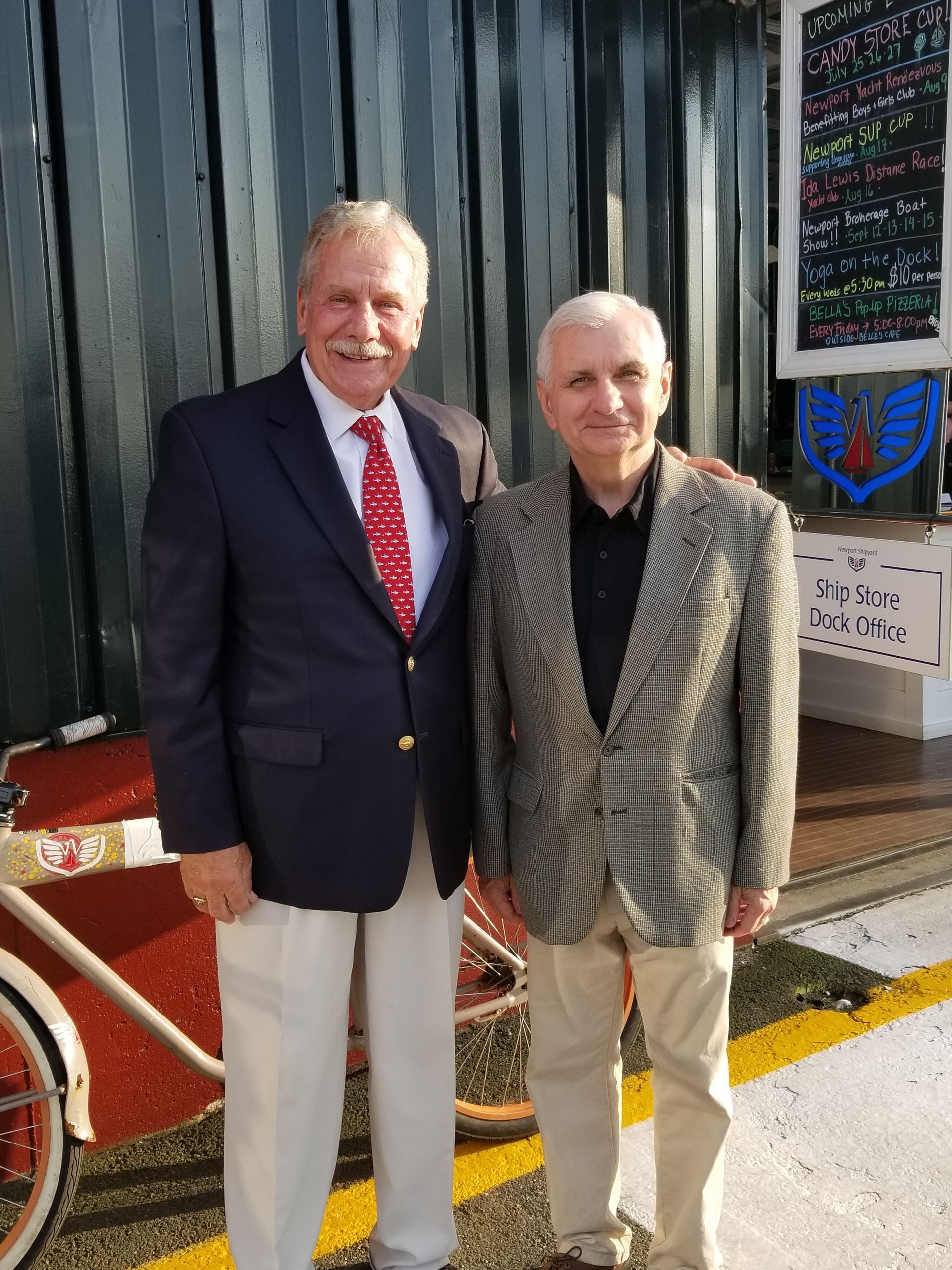 Two men in suits and ties are posing for a picture