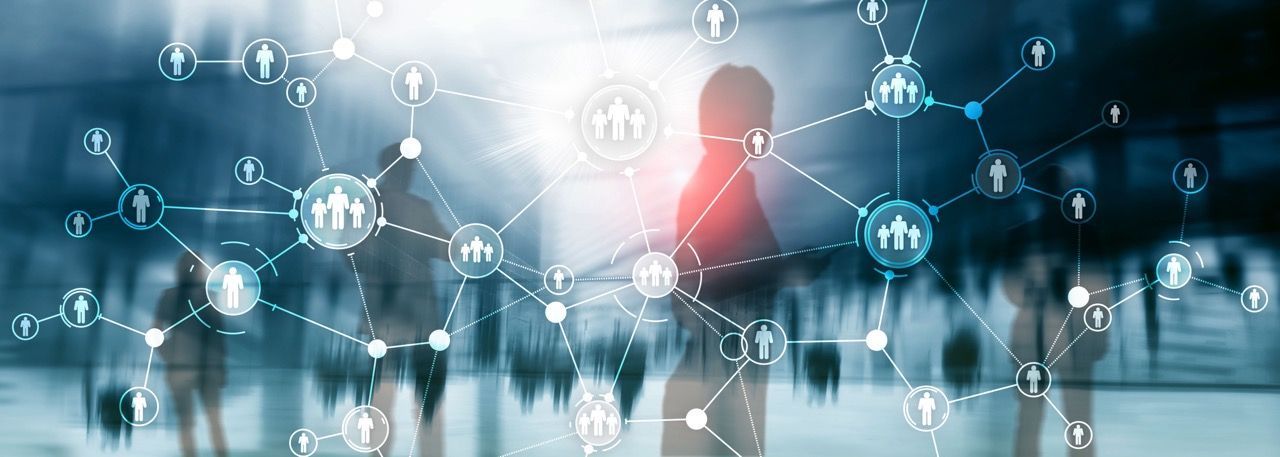 Blurred figures in a cityscape with a digital network overlay, representing interconnectedness and collaboration.