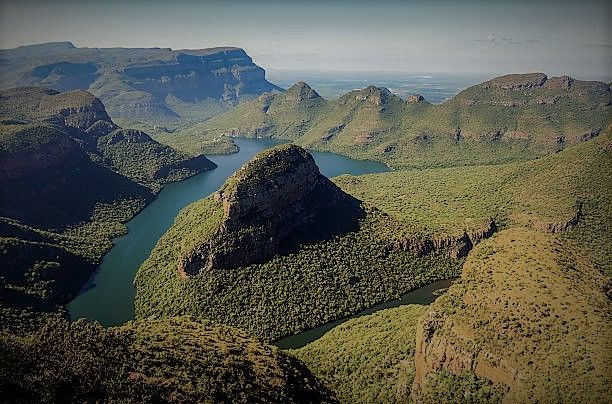 An aerial view of a river surrounded by mountains and trees.