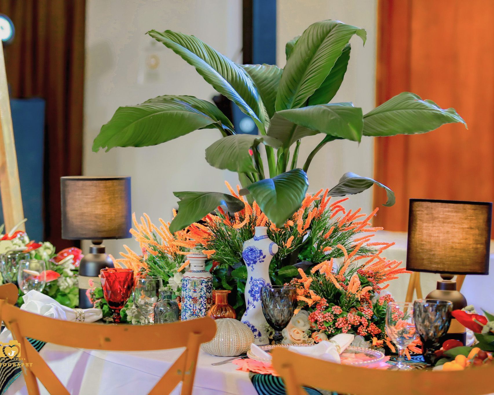 Elegant tropical floral centerpiece with orange blooms at Harvest Hotel eve