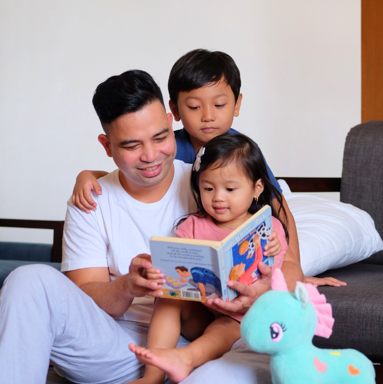 Father reading a storybook with two young children at Harvest Hotel