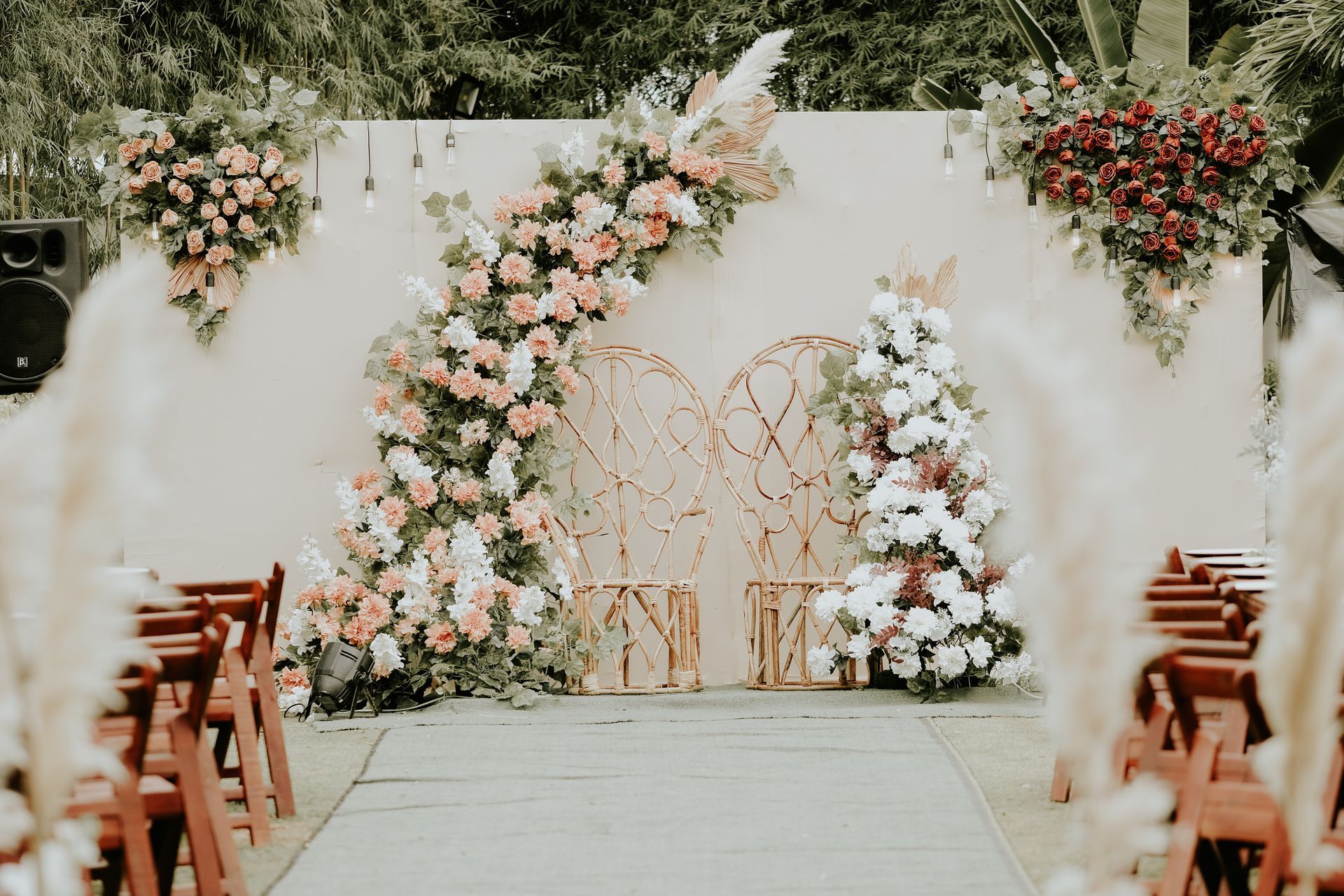 Wedding ceremony backdrop with floral arch and rows of seating.