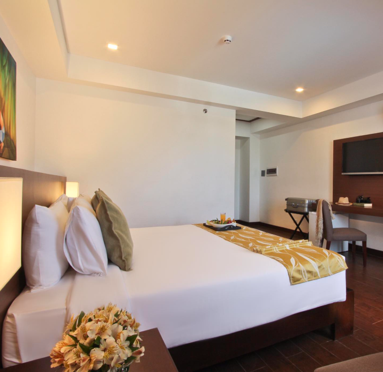 Spacious hotel room with king bed and modern amenities at Harvest Hotel