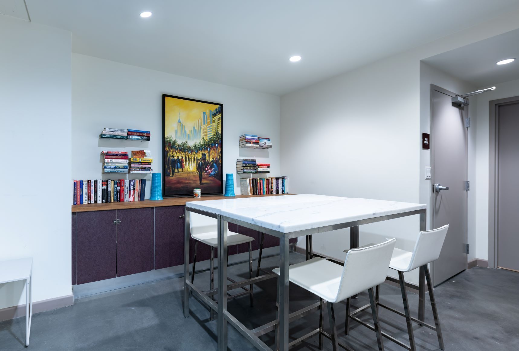 Modern dining room with a table, white chairs, purple storage cabinet, and recessed lighting