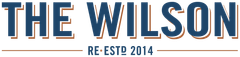 The Wilson logo in blue and orange text with “RE-ESTD 2014” underneath.