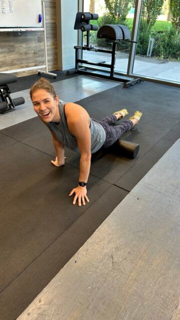 Emily looks like she's having too much fun on the foam roller! A member laughing while using a foam roller