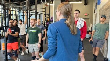 Coach Agne delivering the workout standards. A coach giving out workout instructions