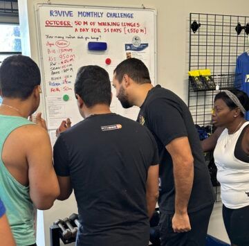 Athletes huddling around the posted events. A group of athletes huddled around the posted workout events.