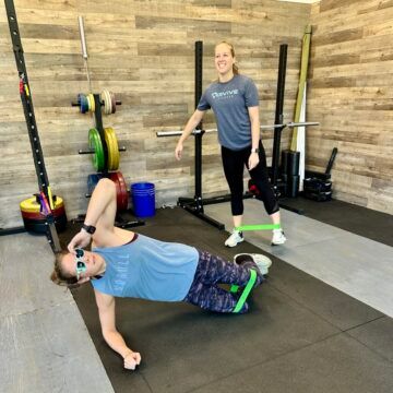 Em and Ari are looking too cool for school as they warm up for event 2. Two athletes performing a warm up using resistance bands.