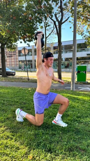 A member performing an overhead walking lunge.