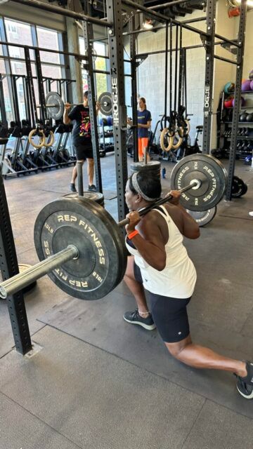 Carol going hard with her step back lunges during event 2. A member performing a backwards lunge using a barbell as part of the second event of our throw down.