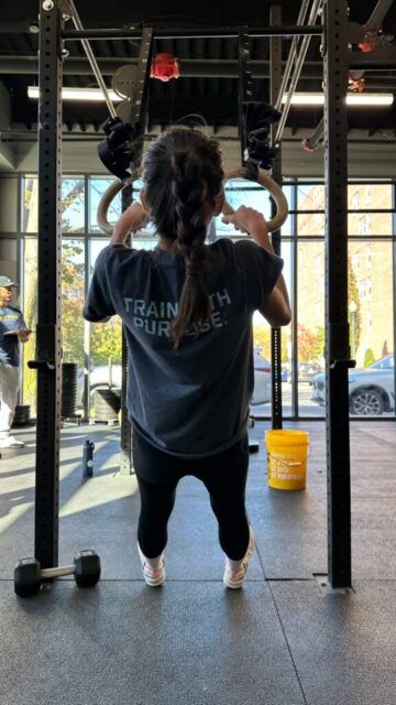 Aspasie cruising through event 3's ring rows. A member performing ring rows.