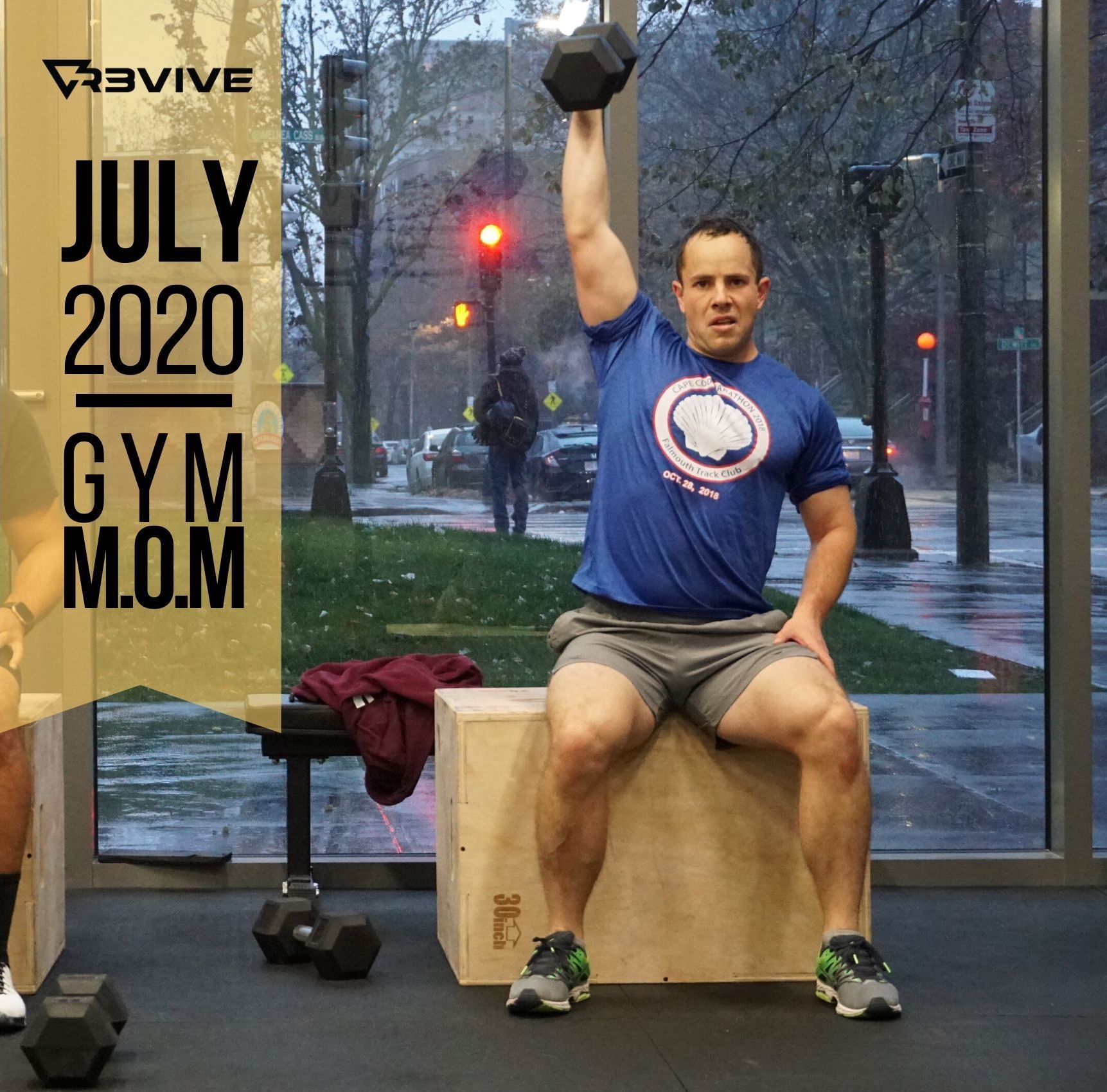 Man sitting on a wooden box, lifting a dumbbell overhead in a gym, July 2020.
