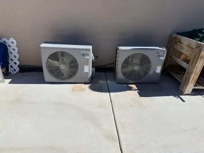 Two newly installed outdoor HVAC units beside a home