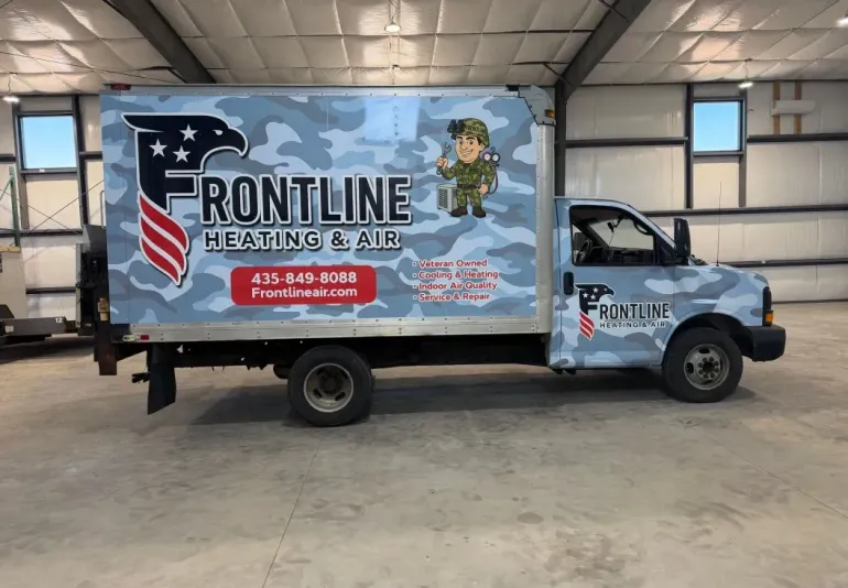 Frontline Heating & Air service truck in a garage, with patriotic graphics and logo on the side.