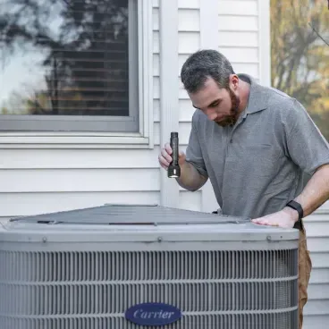 Technician inspecting an outdoor air conditioner at a Southern Utah home