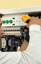 Technician repairing a wall-mounted air conditioner with tools in a home interior