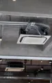 Two outdoor HVAC units on gravel beside a wooden fence and brick wall